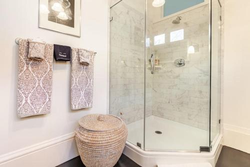 a bathroom with a shower and a wicker stool at Pacific Heights Victorian Garden Suite in San Francisco