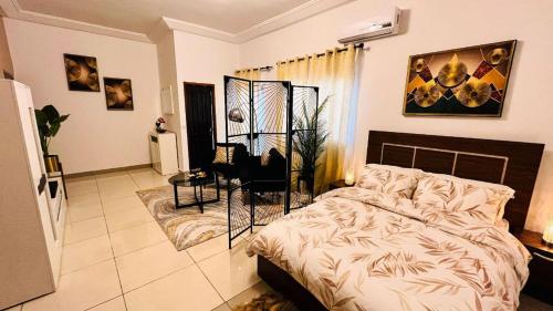 a bedroom with a bed and a chair at Large studio at your disposal in Abidjan in Cocody