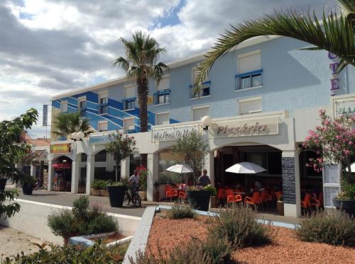 un edificio blu con un ristorante di fronte di Hotel de la Plage - Barcares a Le Barcarès