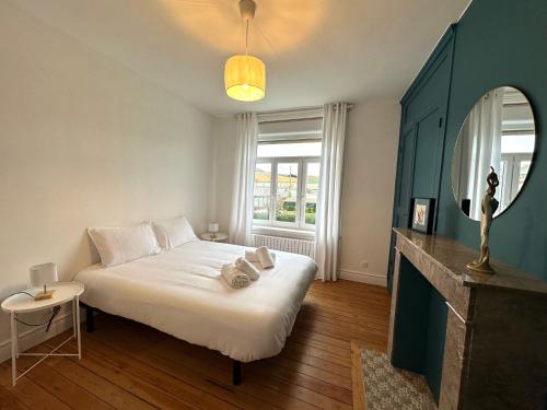 une chambre avec un grand lit blanc avec une fenêtre dans l'établissement Gîte L'Estran à Equihen Plage équipée pour 6 personnes + 1 bébé, à Équihen-Plage