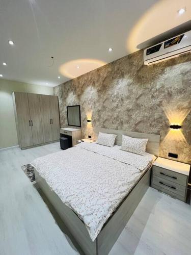 Un dormitorio con una cama grande y una pared en 3-roomed apartment close to the REGISTAN Ozod Apartments en Samarcanda