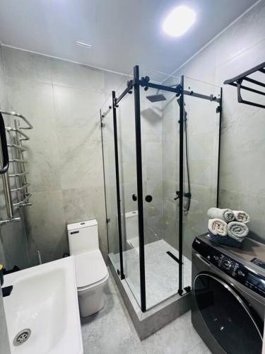 y baño con ducha, aseo y lavamanos. en 3-roomed apartment close to the REGISTAN Ozod Apartments, en Samarkand