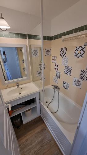 une salle de bain avec une baignoire blanche et un lavabo dans l'établissement BISCARROSSE Appartement avec terrasse PISCINE LAC OCEAN GOLF, à Biscarrosse