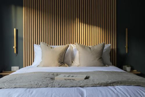 a bed with white pillows and a book on it at Beautiful Oxford Townhouse near City Centre in Oxford