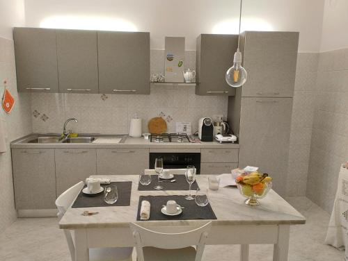una cocina blanca con mesa y sillas. en A CASA IDA, en Bagnoregio