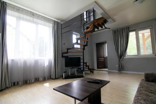 a living room with a spiral staircase and a table at WOW House Lviv in Lviv