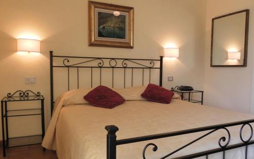 a bedroom with a bed with two red pillows on it at Hotel Il Caminetto in Portoferraio