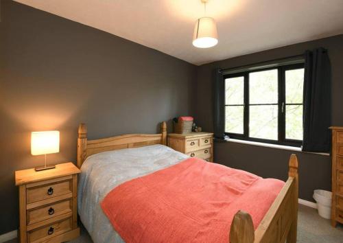 1 dormitorio con cama, lámpara y ventana en Spacious Walthamstow Apartment, en Londres
