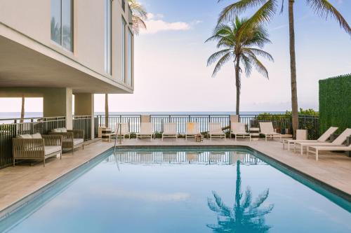a swimming pool with a view of the ocean at The Hillsboro powered by Sonder in Deerfield Beach