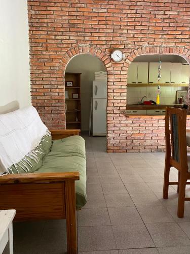 una cocina con una pared de ladrillo y una cama en una habitación en El Lirio Blan - Alquiler temporario en Capilla del Monte