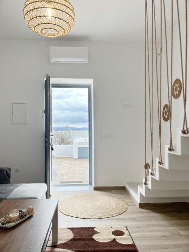 a living room with a staircase and a glass door at Sorokos House in Dhragoulás