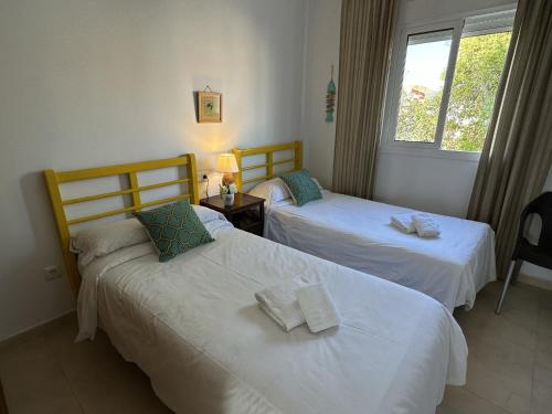 Habitación de hotel con 2 camas y ventana en Nerja Paradise Rentals - Apt Chimenea C1D, en Nerja