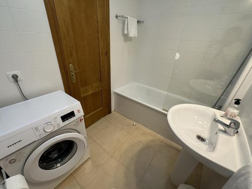 y baño con lavadora y lavamanos. en Nerja Paradise Rentals - Apt Chimenea C1D, en Nerja