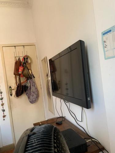 a flat screen tv hanging on a wall at Quarto confortável em Copacabana in Rio de Janeiro