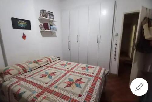 um quarto com uma cama com uma colcha em Quarto confortável em Copacabana no Rio de Janeiro
