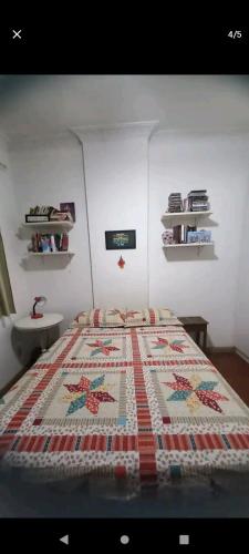 um quarto com uma cama com uma colcha em Quarto confortável em Copacabana no Rio de Janeiro