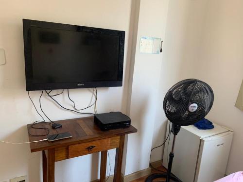 Habitación con TV y ventilador en una mesa. en Quarto confortável em Copacabana, en Río de Janeiro