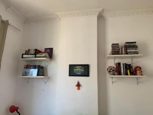 a room with two shelves on the wall with books at Quarto confortável em Copacabana in Rio de Janeiro
