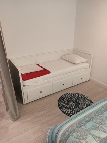 a white bed in a room next to a wall at Apartments Drago Kovačić in Omiš