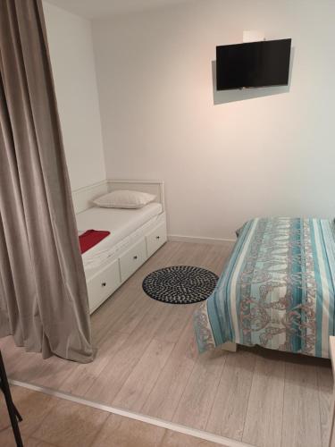 a bedroom with a bed and a tv on the wall at Apartments Drago Kovačić in Omiš