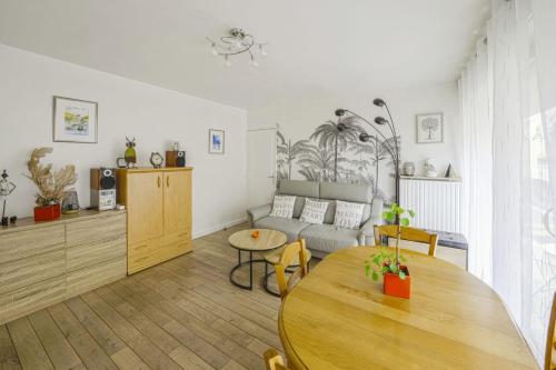 salon ze stołem i kanapą w obiekcie Appartement Labrouste et son balcon - Welkeys w Paryżu