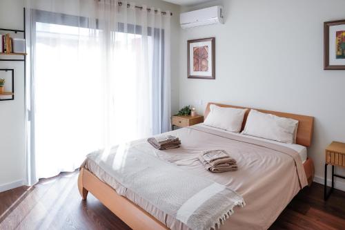 1 dormitorio con 1 cama grande y toallas. en Taste Tavira (by Annick) fully equipped apartment, tastefully decorated, perfect location and free parkingric center of the city of Tavira., en Tavira