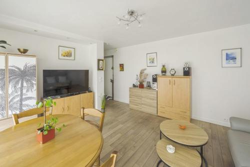 un salon avec un canapé, une table et des chaises dans l'établissement Appartement Labrouste et son balcon - Welkeys, à Paris