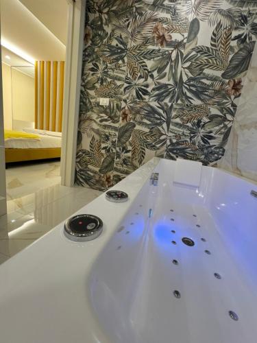 a white bath tub in a bathroom with a wall at Hotel Smeraldo in Qualiano