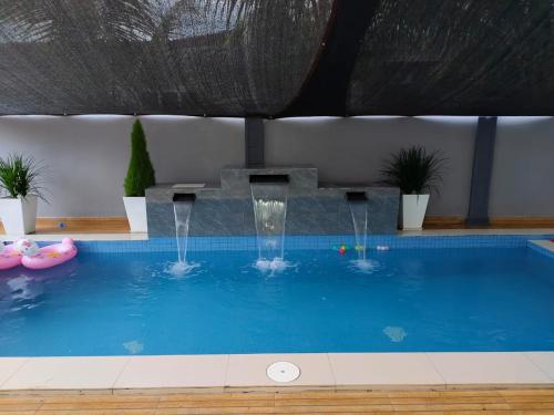 a large swimming pool with a water fountain at NASUHA HOMESTAY 1 TEMERLOH Semi-D House, 4 Bedroom, 3 Bathroom, 5 Unit Aircond, Free Wifi and Netflix, Near Hospital with Private Pool in Temerloh