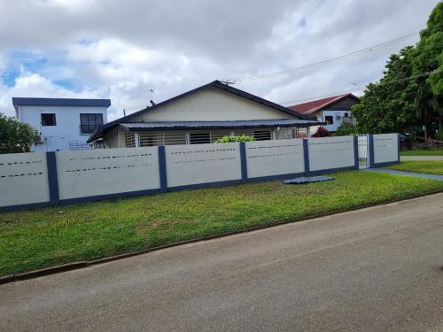 una cerca blanca frente a una casa en THE NICHE STUDIO, en Paramaribo