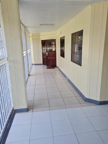 un pasillo vacío de un edificio con puertas rojas en THE NICHE STUDIO en Paramaribo