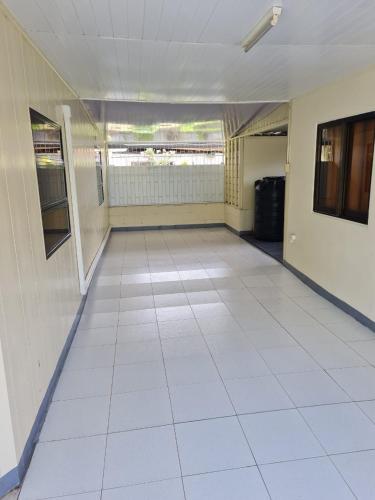 een lege kamer met een witte tegelvloer bij THE NICHE STUDIO in Paramaribo