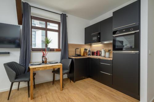 uma cozinha com armários pretos e uma mesa e cadeiras em SweetHome - Zentral - Küche & Parkplatz, WiFi em Halle an der Saale