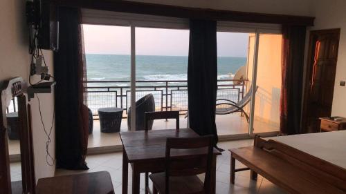 salon ze stołem i widokiem na ocean w obiekcie Annexe RAOOF HOTEL w mieście Mahajanga