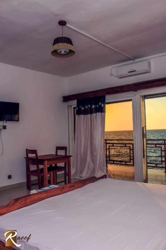 a bedroom with a bed and a view of the ocean at Annexe RAOOF HOTEL in Mahajanga