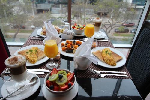 a table topped with plates of breakfast foods and drinks at Hilton Garden Inn Lima Surco in Lima