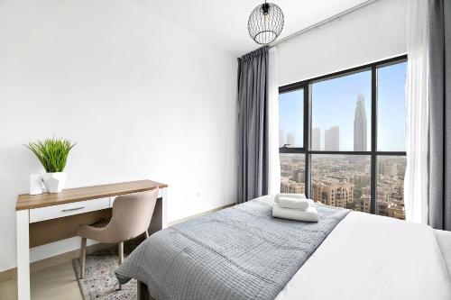 a bedroom with a desk and a bed and a window at VayK - Classy 2BD with Burj Khalifa View in Downtown in Dubai