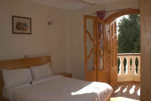 a bedroom with a bed and an open door at Morning Start Apartments in Luxor