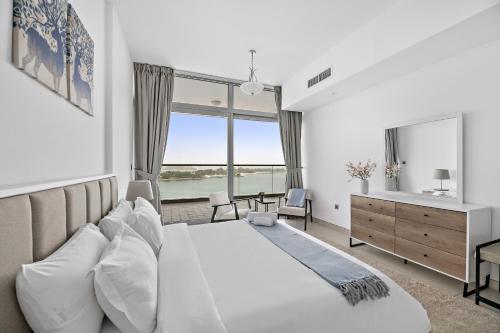 a bedroom with a large bed with a large window at VayK - Serene 1BD with Full Sea View on the Palm in Dubai