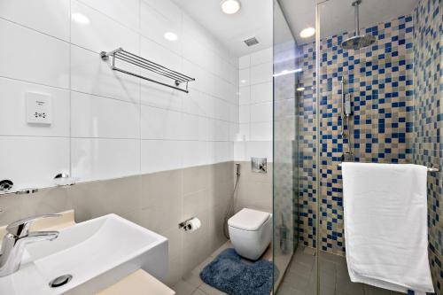 a bathroom with a sink and a toilet and a shower at VayK - Serene 1BD with Full Sea View on the Palm in Dubai