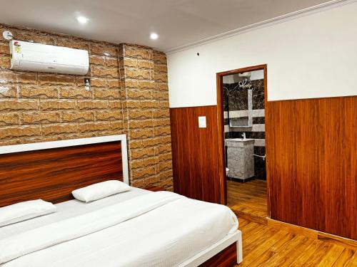 Hotel Walk Inn في فريد آباد: غرفة نوم بسرير وجدار من الطوب