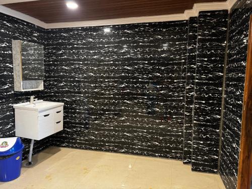 a bathroom with a black wall covered in wine bottles at Hotel Walk Inn in Faridabad