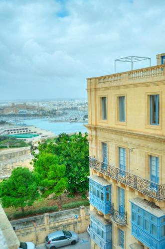a building with blue windows and a balcony at Charming 3 storey apartment in Valletta centre, NGRI1-1 in Valletta