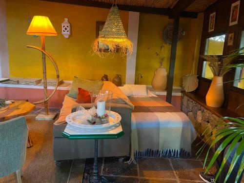 Un dormitorio con una cama y una mesa con una vela en Finca Cebollino en La Orotava