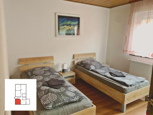 2 camas en una habitación con una foto en la pared en Monteurzimmer/ Ferienwohnung Kati, en Albstadt