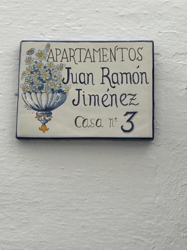 a sign on the side of a white wall at APARTAMENTOS JUAN RAMÓN JIMÉNEZ 3 in Utrera