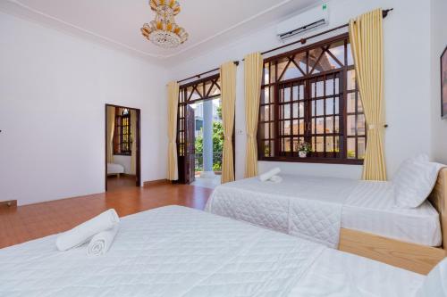 ein Schlafzimmer mit zwei Betten und einem großen Fenster in der Unterkunft Villa Hồ Bơi Bãi Sau - Free Loa Kéo + Bida - Gần Biển - 10/11B LLQ in Vũng Tàu