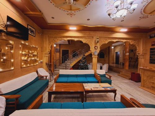 una sala de estar con sofás azules y una escalera. en Hotel Tokyo Palace, en Jaisalmer