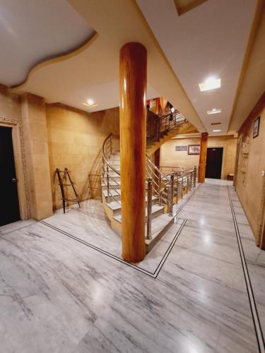 a large room with a wooden pillar and stairs at Hotel Tokyo Palace in Jaisalmer