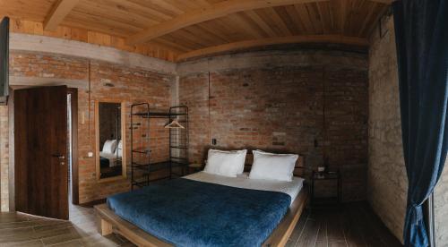 a bedroom with a bed and a brick wall at Crama Mircesti 